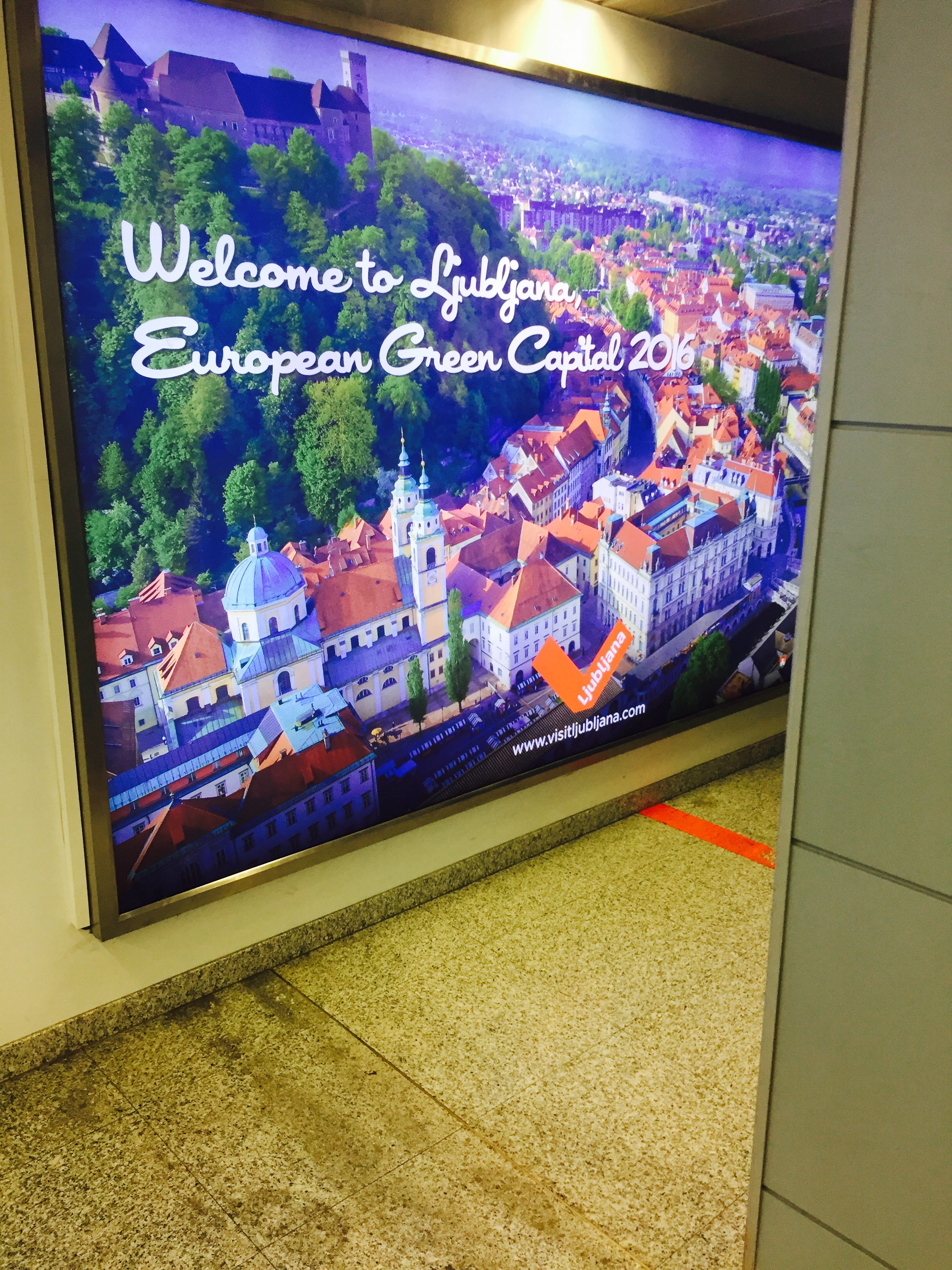 Her er byen avfotografert på poster hengende i ankomstterminalen på flyplassen.