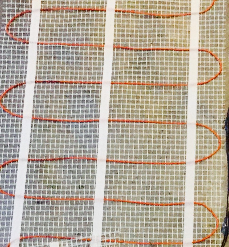 Varmekabler blir lagt i gulvene over hele kjelleren. Fra iskald til deilig lunk.